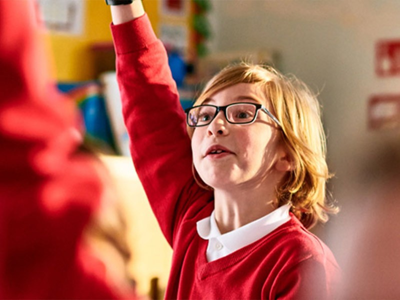 A school girl raising her hand