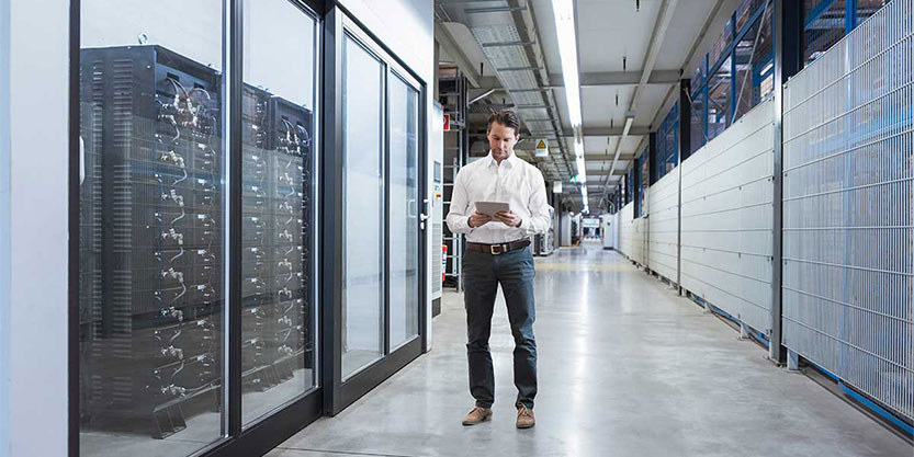 Businessman using tablet in modern data center.