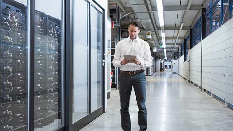 Businessman using tablet in modern data center.