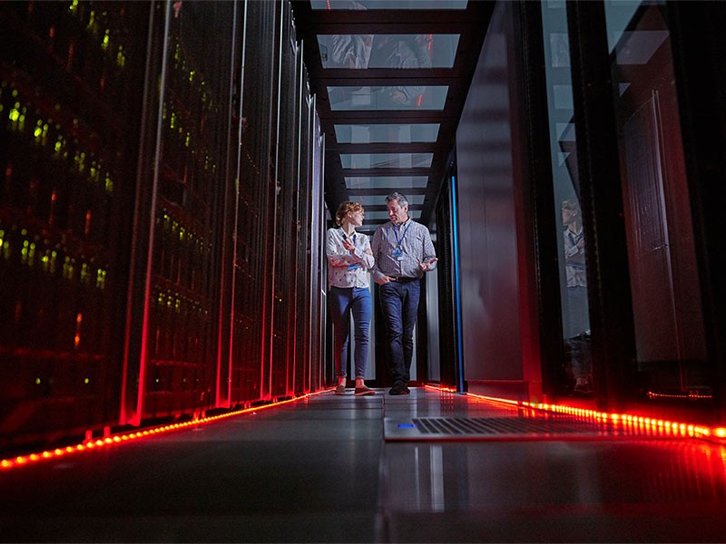 IT technicians walking in dark server room